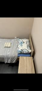 Una pequeña habitación con una cama con una sábana y un banco. en Jack coffee hostel 7, en Sremski Karlovci