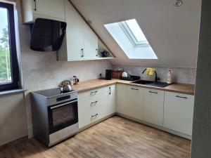 a kitchen with a stove and a sink and a window at Apartament Fort 206 in Ujkowice