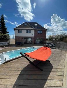 a hammock sitting on a deck next to a pool at Branksome house Worcester in Worcester