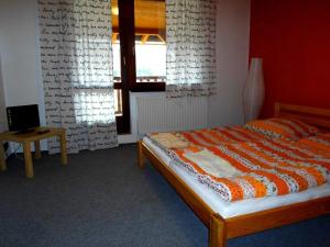 a bedroom with a bed and a table and a window at Penzion Na přehradě in Smradávka