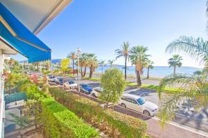 a view of a parking lot with palm trees and the ocean at Le Copacabana Riviera in Nice