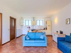 Una sala de estar con un sofá azul y una cocina. en Apartment Vecchia Filanda - MSO150 Apartment 300 by Interhome, en Musso