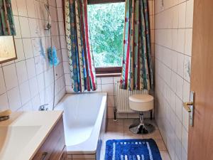 a bathroom with a tub and a sink and a window at Apartment Eleonore by Interhome in Litzlberg