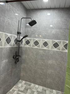 a shower with a shower head in a bathroom at House in the Bamboos in Batumi