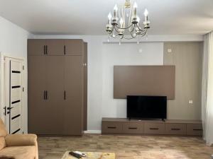 a living room with a flat screen tv and a chandelier at House in the Bamboos in Batumi