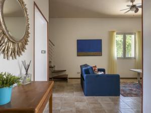a living room with a blue chair and a mirror at Holiday Home Norbert by Interhome in Siracusa
