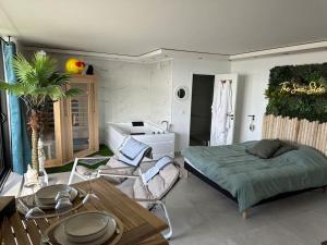 a bedroom with a bed and a table and chairs at Sea Side Calais vue mer in Calais