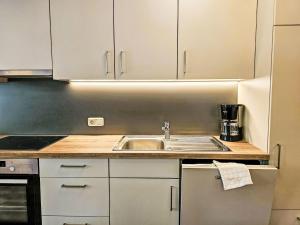 a kitchen with white cabinets and a sink at Apartment Inn by Interhome in See