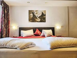 a bedroom with two beds and a painting on the wall at Apartment Inn by Interhome in See