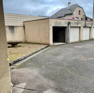 a building with a large garage with a garage door at Chez Marius et Rosalie in Espalion