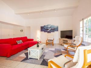 ein Wohnzimmer mit einem roten Sofa und einem Fernseher in der Unterkunft Villa Ohana by Interhome in Sainte-Maxime