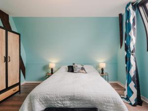 1 dormitorio con 1 cama con paredes azules y 2 lámparas en Villa Blanc Castel by Interhome, en Saint-Briac-sur-Mer