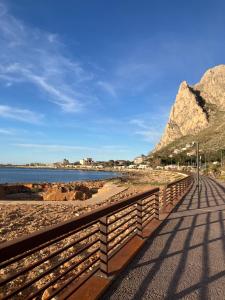 Un paseo marítimo en la playa con montañas al fondo en Itaca, en Palermo