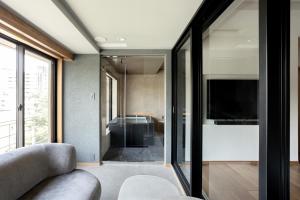 a living room with a couch and a tv at Arima Onsen Takayamaso Hanano in Kobe