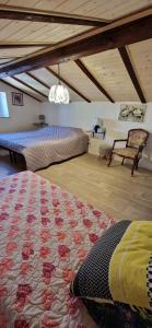 a attic room with two beds and a chair at Bouganville in Villanovafranca