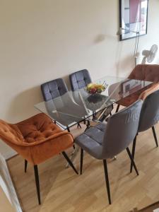 a dining room with a glass table and chairs at Hunters Wharf River View by Select SA in Reading