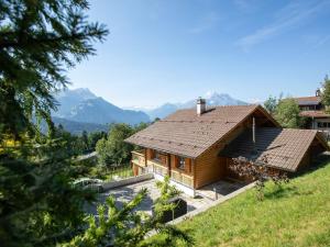 a log house with mountains in the background at Chalet Chalet Domino by Interhome in Chesières