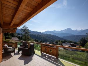 a balcony with chairs and a view of mountains at Chalet Chalet Domino by Interhome in Chesières
