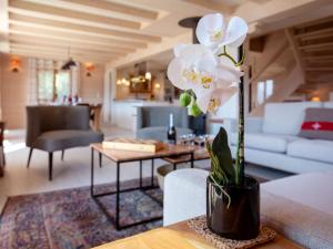 a vase with white flowers on a table in a living room at Chalet Chalet Domino by Interhome in Chesières