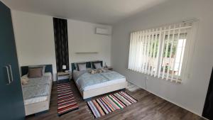 a bedroom with two beds and a window at Luxurious Lakeview Retreat in Vonyarcvashegy in Vonyarcvashegy +3 photos