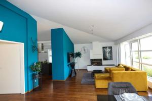 a living room with a yellow couch and blue walls at Regensburgs grandioses Apartment in Sinzing