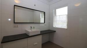 a white bathroom with a sink and a mirror at Golden Circle Spectacular house! in Ásborgir +12 photos