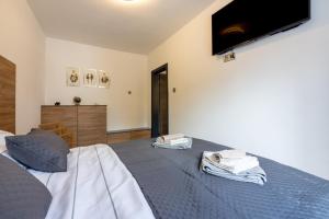 a bedroom with a bed with a tv on the wall at Nika in Crikvenica