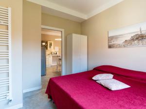a bedroom with a bed with a red blanket at Apartment Nives by Interhome in Diano Marina