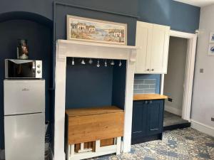a kitchen with blue walls and a white refrigerator at Crown Cove in Pakefield