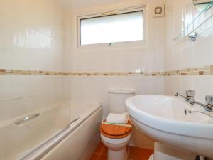 a bathroom with a toilet and a sink and a tub at Newtrain Bay in Padstow