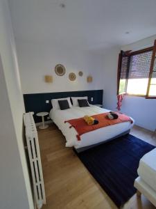 a bedroom with a large bed and a window at Au Pti' Bonheur in Saint-Coulomb
