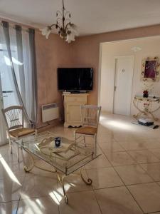 a living room with a glass table and chairs at Agréable maison au cœur de St Hilaire in Saint-Hilaire-de-Riez