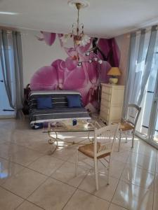 a living room with a bed and a table and chairs at Agréable maison au cœur de St Hilaire in Saint-Hilaire-de-Riez +2 photos