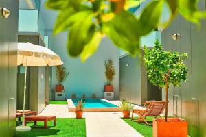 una piscina en medio de un patio con sillas y sombrilla en Beautiful Town Centre Townhouse With Shared Pool, en Tavira