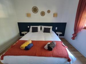 a bedroom with a large bed with two pillows at Au Pti' Bonheur in Saint-Coulomb
