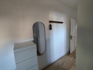 a room with a mirror and a dresser and a door at Au Pti' Bonheur in Saint-Coulomb