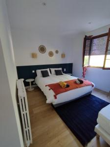 a bedroom with a large bed and a window at Au Pti' Bonheur in Saint-Coulomb