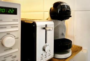 a coffee maker sitting on a counter next to a microwave at Miradoiro 38 in Lira