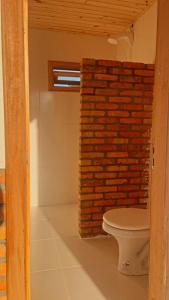 a bathroom with a brick wall and a toilet at Espaço Vitali in Blinha