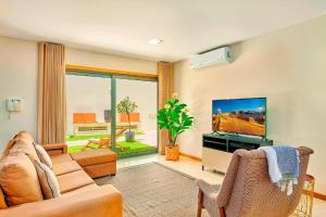 a living room with a couch and a flat screen tv at Stunning Townhouse With Pool In Tavira Centre in Tavira