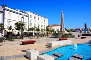 a fountain in a square in a city with buildings at Stunning Townhouse With Pool In Tavira Centre in Tavira