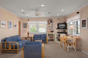 een woonkamer met een blauwe bank en een tafel bij SNH448 L'il Seabreeze in Nags Head