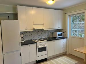 a kitchen with white cabinets and a white stove top oven at Harbo House in Norberg