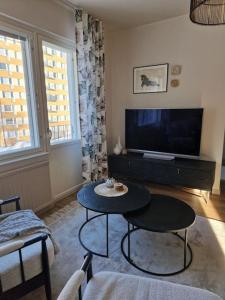 a living room with a table and a tv at 50s Atmospheric Suite in Turku