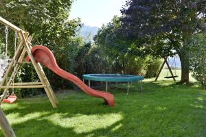 un parque infantil con un tobogán y una mesa en el césped en Klausnerhof en Aschau