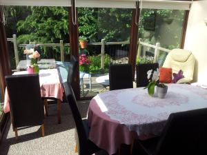 a dining room with a table and chairs with flowers on it at Kingfisher Cottage in Tavistock