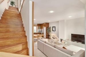 a living room with a couch and a staircase at Stylish Townhouse In Tavira Centre, Shared Pool in Tavira