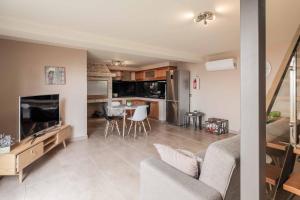 Una sala de estar y una cocina con un sofá y una mesa. en Villa Oceanscape, en Madalena do Mar