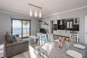Una cocina y una sala de estar con una mesa y un sofá. en Villa Oceanscape, en Madalena do Mar