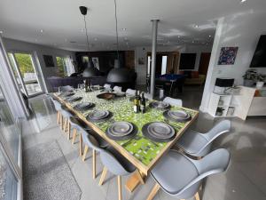 a long table with plates and dishes on it at 5 Bed House-Sleeps 14-Hot Tub-Bar-Garden-Parking in Tavistock